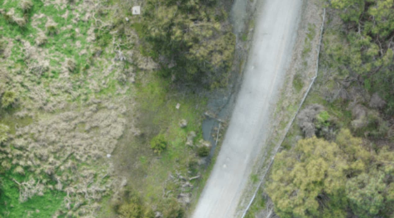 Visual aerial image of an access corridor beside vegetation and water