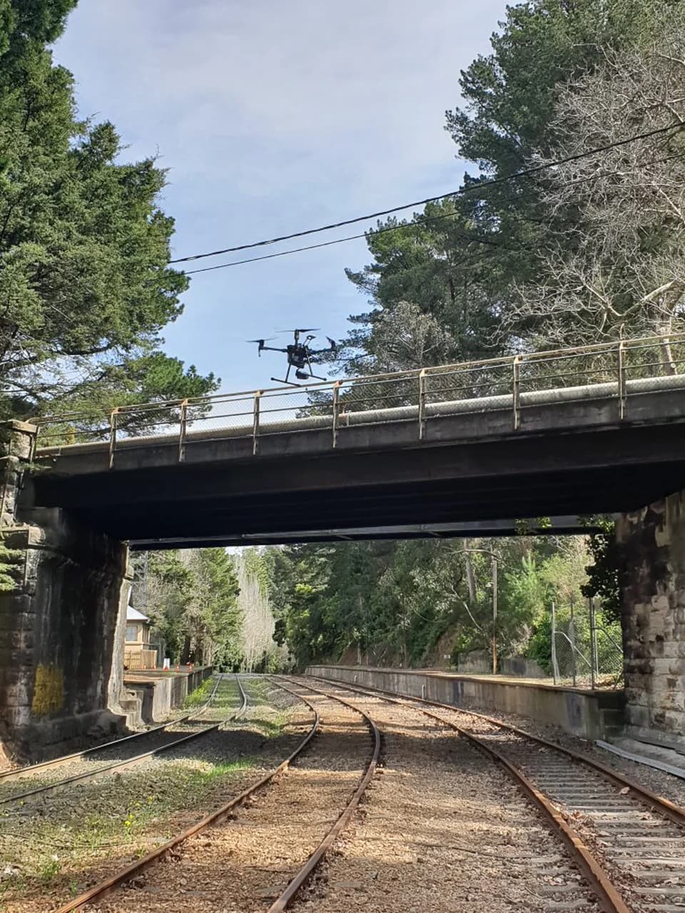 Drone above a bridge crossing railway tracks