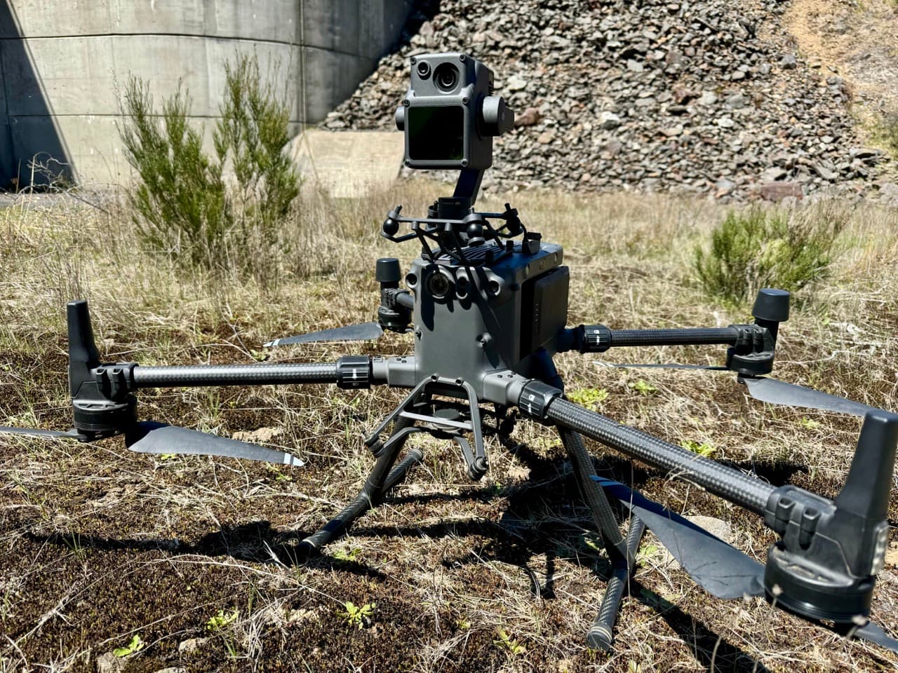 National Drones survey aircraft fitted with a sensor beside concrete infrastructure