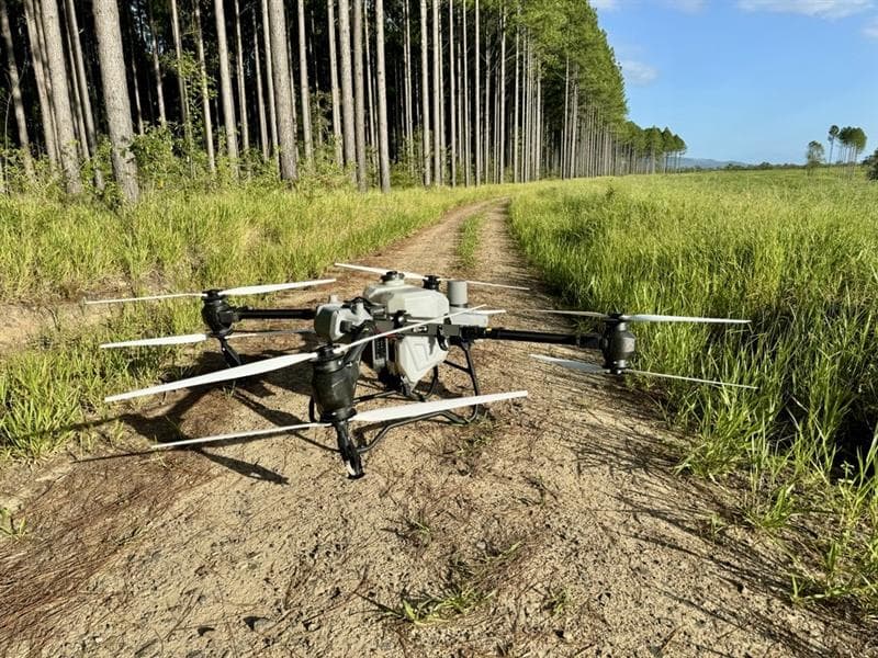 DJI Agras spraying drone on a forestry track